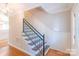Stairway with wood flooring, white wainscoting, and a modern railing at 3921 Bon Rea Dr, Charlotte, NC 28226