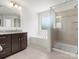 This primary bathroom has a white standalone bathtub, a dark cabinet with light countertop, and a glass-door shower with tile surround at 4013 Hamilton Mill Dr, Waxhaw, NC 28173