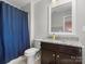 Bathroom featuring dark cabinets, granite countertop, toilet, and shower with blue shower curtain and bright vanity lighting at 4013 Hamilton Mill Dr, Waxhaw, NC 28173