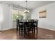 Dining area features a black wood table with black leather chairs and natural lighting at 4013 Hamilton Mill Dr, Waxhaw, NC 28173