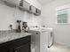 Bright laundry room features modern washer and dryer, sleek countertops, and ample storage shelving at 4013 Hamilton Mill Dr, Waxhaw, NC 28173