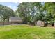A spacious backyard view includes a pool, storage shed, lush lawn, and privacy fence at 4024 Tyndale Ave, Charlotte, NC 28210