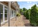 A backyard view features a stone and gravel walkway, neat landscaping, and a pergola near the house at 4024 Tyndale Ave, Charlotte, NC 28210