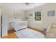 Cozy Bedroom with a white crib, hardwood floors, and a soft color palette at 4024 Tyndale Ave, Charlotte, NC 28210