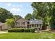 Charming two-story home featuring a well-maintained lawn, mature trees, and a cozy outdoor seating area at 4024 Tyndale Ave, Charlotte, NC 28210