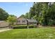 Charming two-story home featuring a well-maintained lawn, mature trees, and a cozy outdoor seating area at 4024 Tyndale Ave, Charlotte, NC 28210