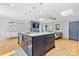 Modern kitchen island with a sink and stainless steel appliances, open to the living area at 4024 Tyndale Ave, Charlotte, NC 28210