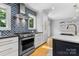 Modern kitchen boasts stainless steel appliances, custom backsplash, and a functional layout at 4024 Tyndale Ave, Charlotte, NC 28210