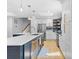 Open-concept kitchen featuring a large island with a sink, stainless steel appliances, and modern lighting at 4024 Tyndale Ave, Charlotte, NC 28210