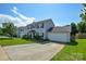 A two-story home with a two-car garage boasts a lush green lawn and a paved driveway at 4075 Clover Nw Rd, Concord, NC 28027