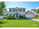 Charming two-story home with a well-manicured lawn, lush landscaping, and an attached two-car garage at 4075 Clover Nw Rd, Concord, NC 28027