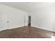 Spacious room with white walls, trim, with wood-look flooring, and a door at 4315 Palm Dr, Denver, NC 28037