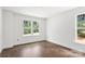 Bright bedroom with hardwood floors and two large windows overlooking lush greenery at 4315 Palm Dr, Denver, NC 28037