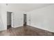 Minimalist bedroom featuring hardwood floors, white walls, and two doors leading to other rooms at 4315 Palm Dr, Denver, NC 28037