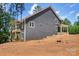 Side view of a gray two-story home with a deck and wooded backdrop at 4315 Palm Dr, Denver, NC 28037
