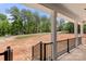 Covered porch with black railings and pillars overlooking the undeveloped lot and street at 4315 Palm Dr, Denver, NC 28037