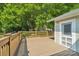 View of the wooden deck with rail and white door that leads to the house, surrounded by lush greenery and mature trees at 448 Union S St, Concord, NC 28025