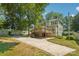 Back of the house with a wooden deck, driveway, and mature trees for shade at 448 Union S St, Concord, NC 28025