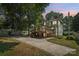 Back of the house with a wooden deck, driveway, and mature trees for shade at 448 Union S St, Concord, NC 28025