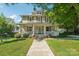 Inviting two-story home featuring a classic porch with a swing, well-manicured lawn, and a welcoming facade at 448 Union S St, Concord, NC 28025