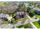 Aerial view of brick home with manicured landscaping, long driveway, and mature trees at 5004 Woodview Ln, Matthews, NC 28104