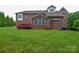 Spacious backyard and brick home exterior with wooden deck at 5004 Woodview Ln, Matthews, NC 28104