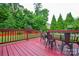 View of deck overlooking backyard with grass, trees, and a basketball hoop at 5004 Woodview Ln, Matthews, NC 28104