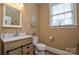 Cozy powder room with wood-look vanity, modern fixtures, and ample natural light at 5004 Woodview Ln, Matthews, NC 28104