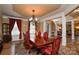 Formal dining room with a large table, elegant chandelier, and rich wood accents at 5004 Woodview Ln, Matthews, NC 28104