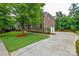 Brick home boasts a circular driveway, three-car garage, and lush landscaping at 5004 Woodview Ln, Matthews, NC 28104