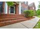 Charming front porch with brick stairs, white columns and mature landscaping at 5004 Woodview Ln, Matthews, NC 28104