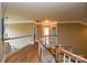 Hallway featuring hardwood floors, white railings, and neutral walls at 5004 Woodview Ln, Matthews, NC 28104