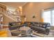 Bright and open living room featuring soaring ceilings, a large sectional, staircase, and lots of natural light at 5004 Woodview Ln, Matthews, NC 28104