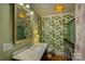 Bright bathroom featuring wallpaper with botanical design and a marble top vanity at 504 S Hayne St, Monroe, NC 28112