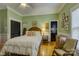 Cozy bedroom featuring hardwood floors, neutral green walls, and a large white bed with decorative pillows at 504 S Hayne St, Monroe, NC 28112