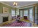 Cozy living room featuring a fireplace, hardwood floors, and many windows for natural light at 504 S Hayne St, Monroe, NC 28112