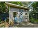 Close-up of the shed showing the inviting entrance with wreath, wooden deck, and tranquil backyard setting at 504 S Hayne St, Monroe, NC 28112