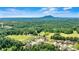Expansive aerial view of a residential area featuring beautiful homes, green spaces, and distant mountain views at 5163 Meadow Park Ln, Hickory, NC 28602