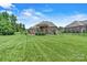 Expansive backyard featuring a well-manicured lawn, patio, and lush landscaping at 5163 Meadow Park Ln, Hickory, NC 28602