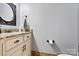 Elegant half bathroom with granite countertop vanity, decorative mirror, and neutral paint scheme at 5163 Meadow Park Ln, Hickory, NC 28602