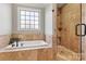 Bathroom featuring a standalone shower with tile surround and large window above soaking tub at 5163 Meadow Park Ln, Hickory, NC 28602