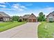 Well-maintained brick home with long driveway, showcasing a manicured lawn and attractive landscaping at 5163 Meadow Park Ln, Hickory, NC 28602