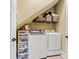 Efficient laundry area with washer, dryer, storage shelves, and practical organization solutions under the sloped ceiling at 5163 Meadow Park Ln, Hickory, NC 28602