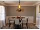 Dining room featuring modern light fixture, wall art, wainscoting and glass table at 5227 Eagle Creek Dr, Charlotte, NC 28269