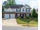 Charming two-story home featuring a well-manicured lawn, two-car garage, and brick and white siding at 5227 Eagle Creek Dr, Charlotte, NC 28269