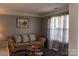 Cozy living room featuring a comfortable sofa and bright natural light through sheer curtains at 5227 Eagle Creek Dr, Charlotte, NC 28269
