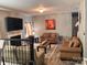Cozy living room with a fireplace, flat screen tv, hardwood floors, and comfortable leather sofas at 5227 Eagle Creek Dr, Charlotte, NC 28269