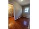 Bedroom with window and hardwood floors, view into bathroom with pedestal sink at 524 Railroad Nw Dr, Concord, NC 28025