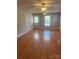 Living room featuring gleaming hardwood floors, two windows, and ceiling fans for comfortable living at 524 Railroad Nw Dr, Concord, NC 28025
