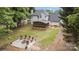 Aerial view showing the backyard, fire pit, screened-in porch, and lush greenery at 5625 Linda Vista Ln, Charlotte, NC 28216